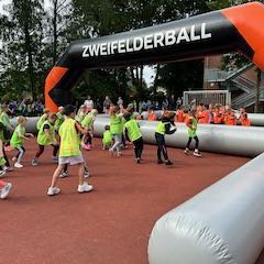 Kinder spielen beim Zweifelderball gegeneinander.