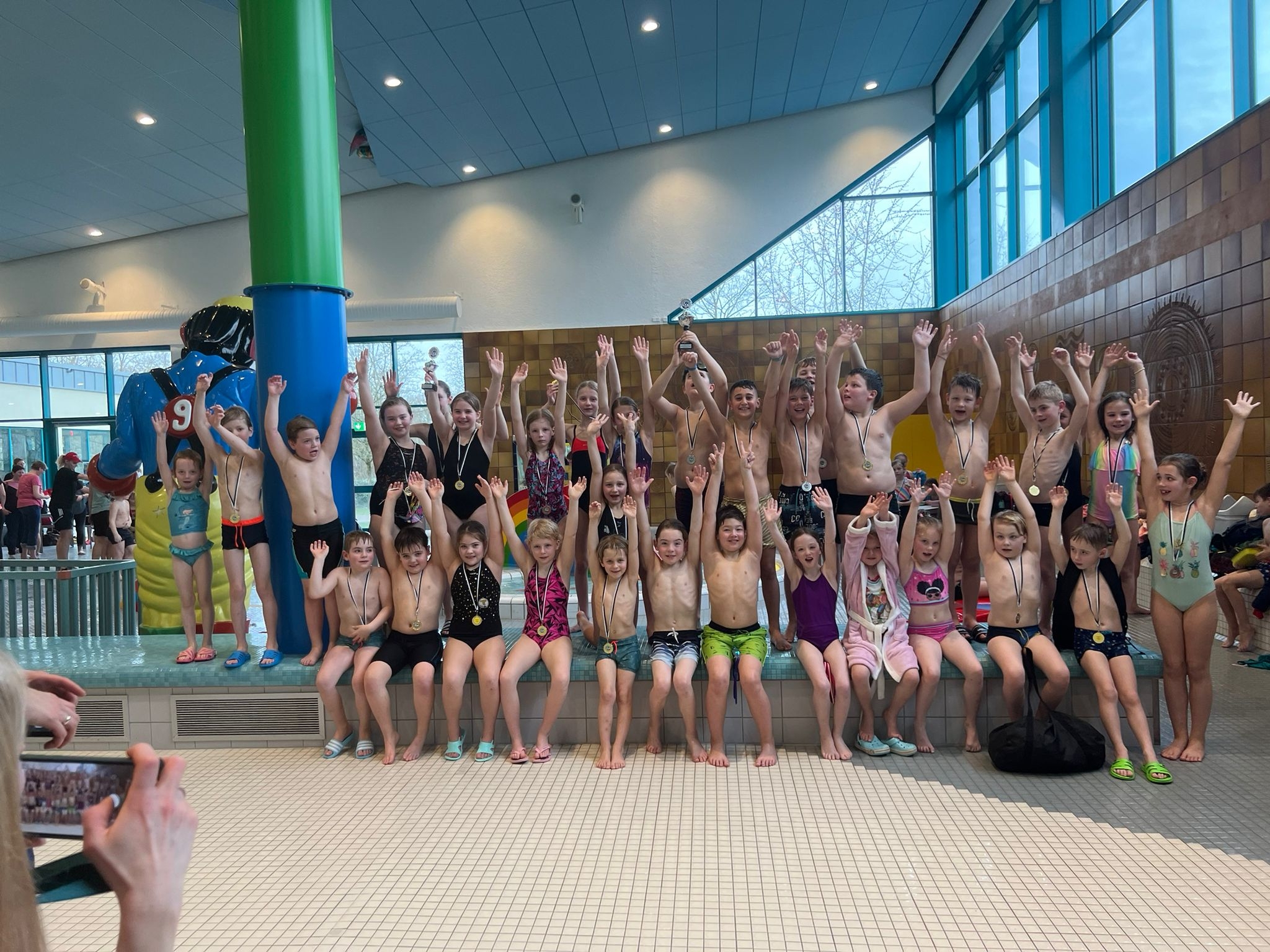 Die Kinder freuen sich über ihre Erfolge beim Schwimmwettkampf.