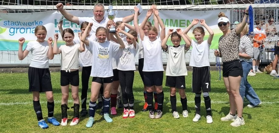 Die Mädchen-Mannschaft freut sich über ihren Pokal.