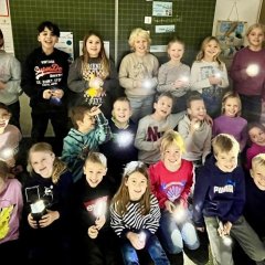 Kinder der dritten Klasse mit Taschenlampen.
