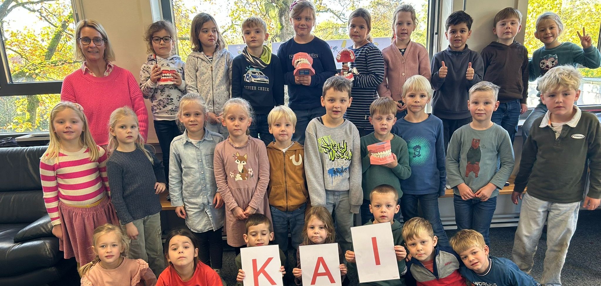 Die Kinder der Eulenklasse halten Schilder für die "KAI"-Methode hoch.