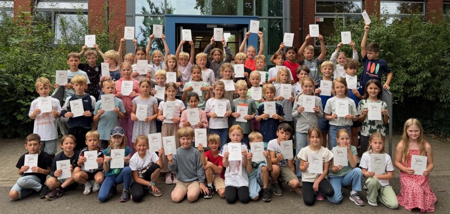 Die Kinder zeigen stolz ihre Ehrenurkunden.