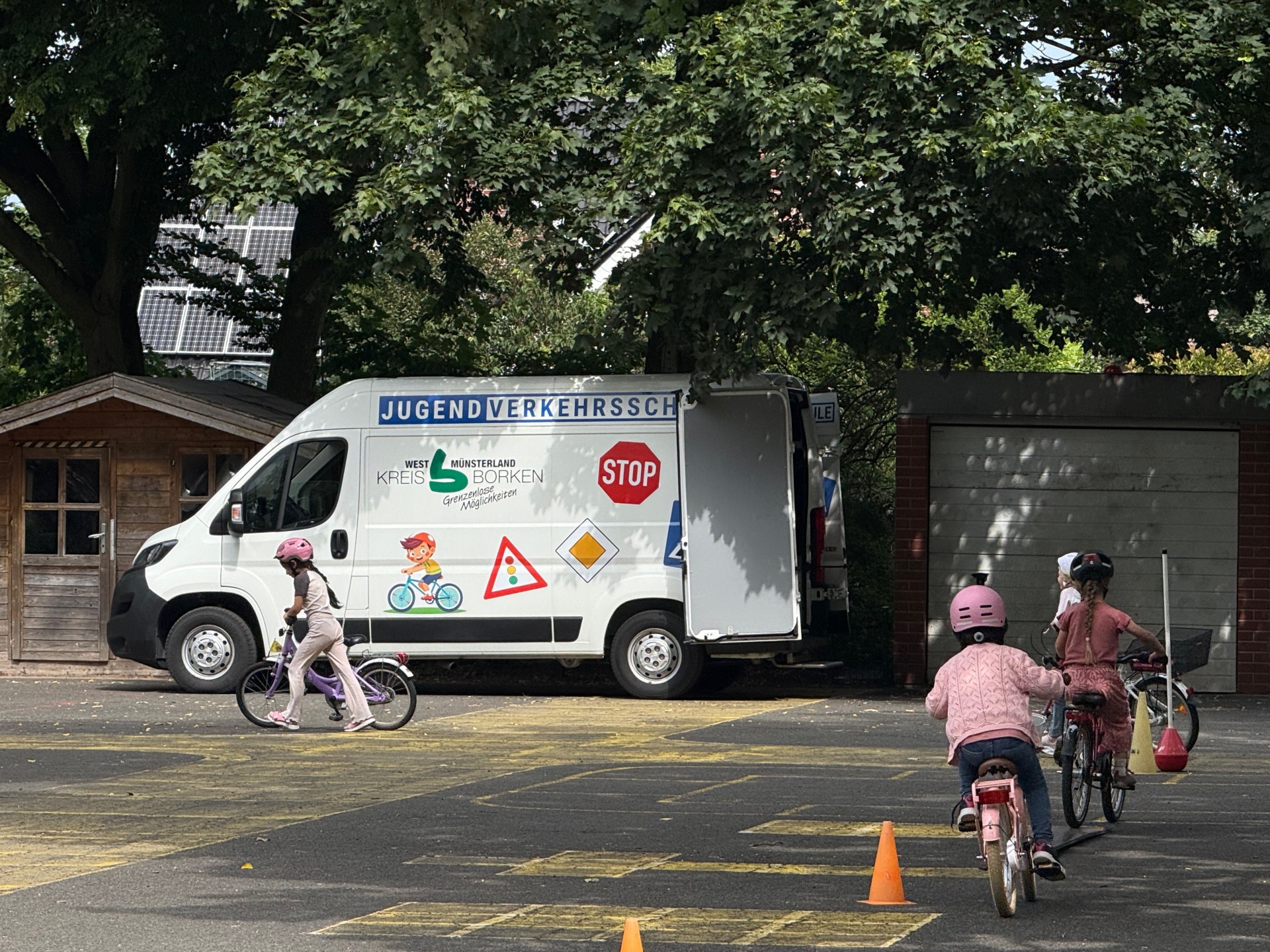 Die Kinder drehen ihre Runden auf dem Fahrrad.