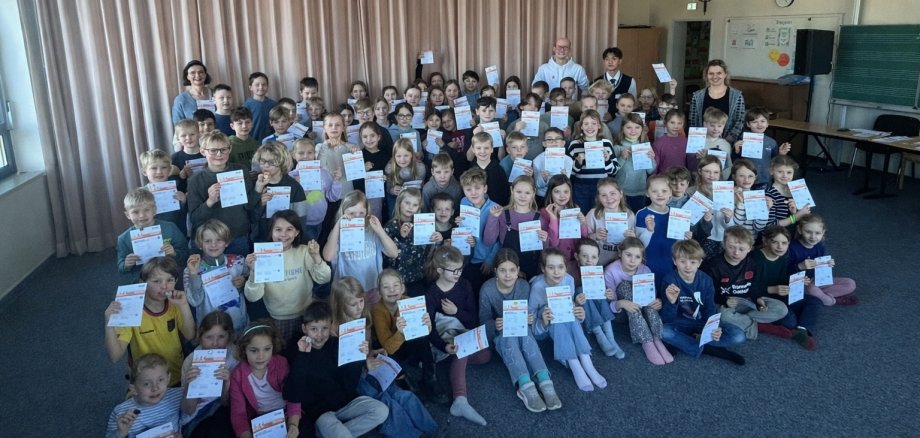 Kinder zeigen stolz ihre Sportabzeichen.