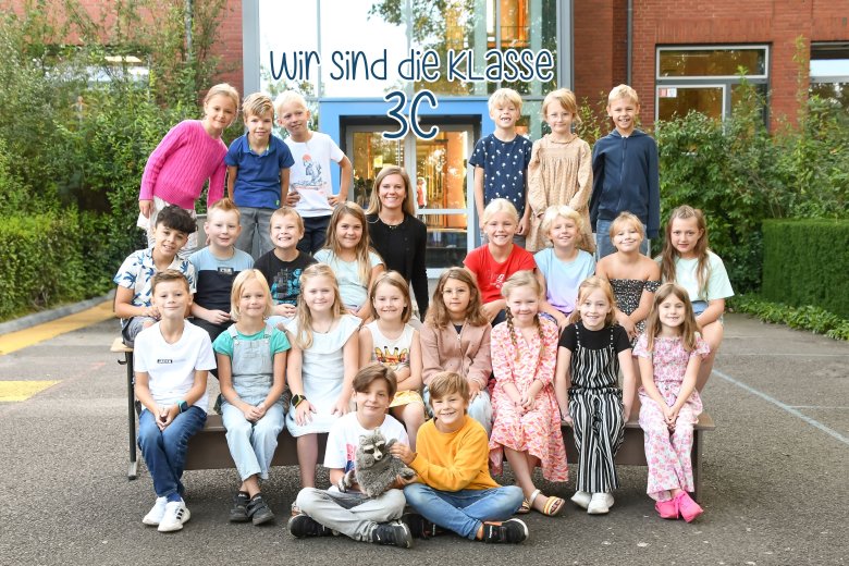 Kinder der Waschbärenklasse mit ihrer Klassenlehrerin und dem Klassentier