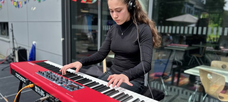 Eine Schülerin spielt auf einer Bühne Klavier beim Europatag an der Gesamtschule Gronau