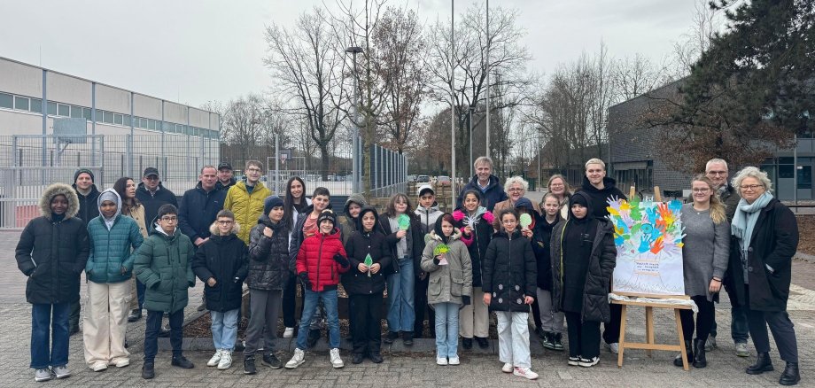 Bürgermeister Rainer Doetkotte, Stadtbaurat Ralf Groß-Holtick, Erste Beigeordnete Christiane Schrader sowie Schulleiterin Frau Steuer und Schüler*innen der Gesamtschule und weiteren Projektbeteiligten vor dem neuen Schulhof.