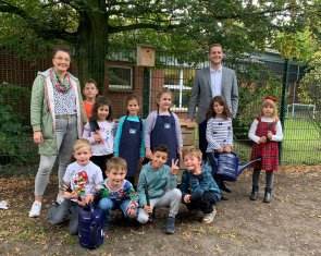 Kinder, Lehrerin und Vertreter der Volksbank Ahaus stehen vor dem Hochbeet.