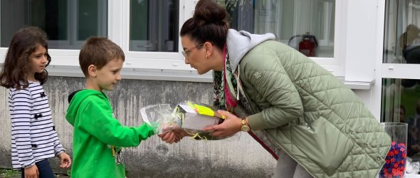 'Konrektorin überreicht einem Jungen seinen Gewinn