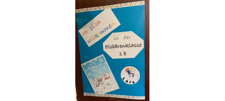 Ein blaues Schild mit der Aufschrift "Herzlich Willkommen in der Eisbärenklasse"