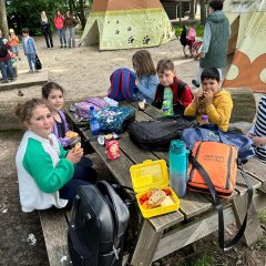 Kinder frühstücken auf der Picknickbank