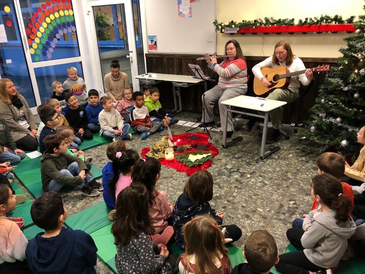 Zwei Frauen spielen Instrumente und Kinder singen dazu