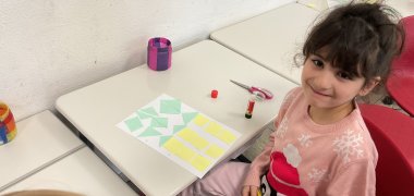 Ein Mädchen bastelt mit geometrischen Formen