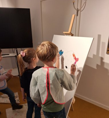 Kinder bemalen eine Leinwand