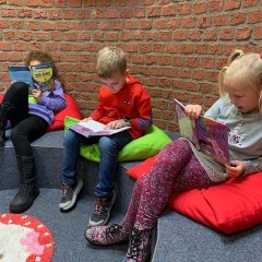 Drei Kinder lesen in der Leseecke