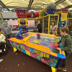 Kinder, Betreuer und Altenheimbewohner auf dem Spielplatz